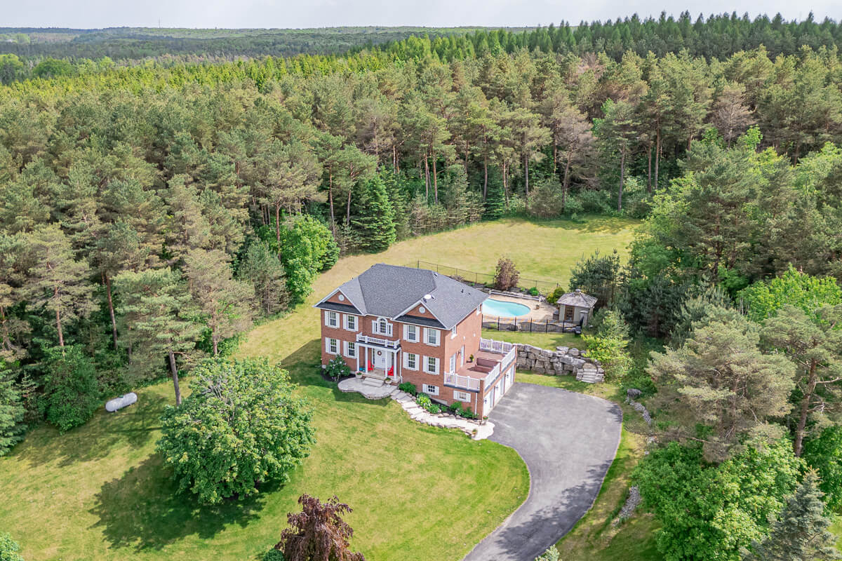 Toronto aerial drone real estate photography luxury brick home with pool surrounded by forest