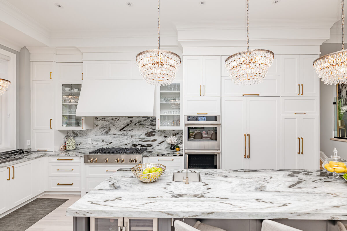 Luxury white kitchen with marble island and chandeliers, real estate photography Toronto