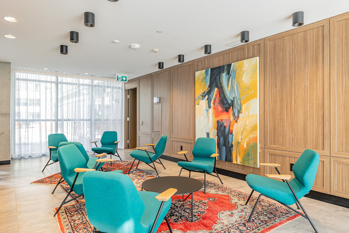 Modern commercial lounge with green chairs and artwork, commercial real estate photography Toronto