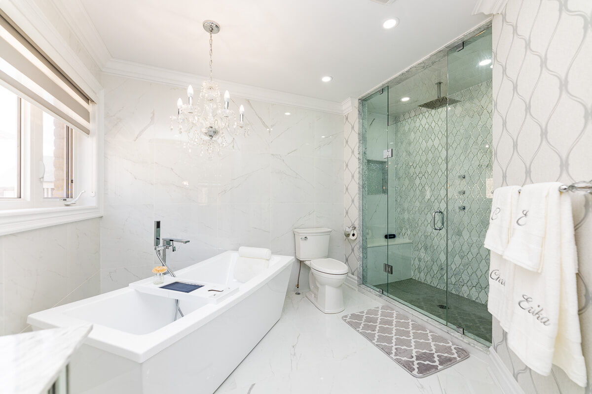 Elegant bathroom with glass shower and bathtub, luxury real estate photography Toronto