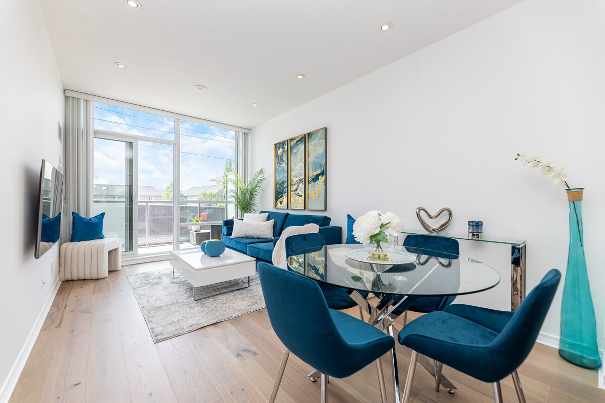 Modern condo living room with blue furniture and balcony view, condo photography Toronto