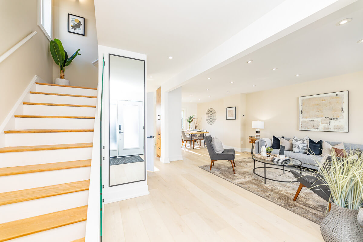 Bright entryway with staircase and open living space, real estate interior photography Toronto
