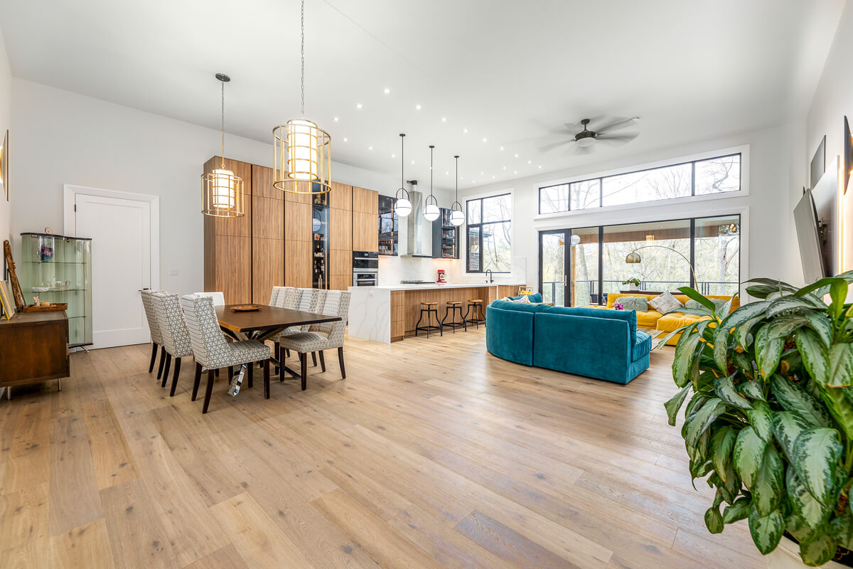 Open concept kitchen dining and living area with wood accents, real estate photography Toronto