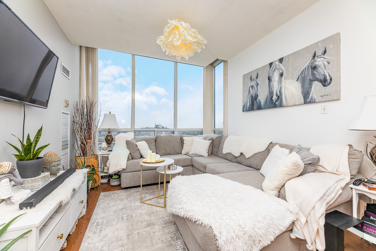 Corner condo living room with large windows and city view, condo photography Toronto