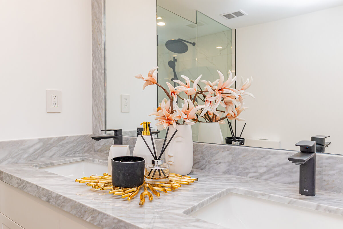 Modern bathroom vanity with marble countertop and decorative flowers, real estate photography Toronto bathroom