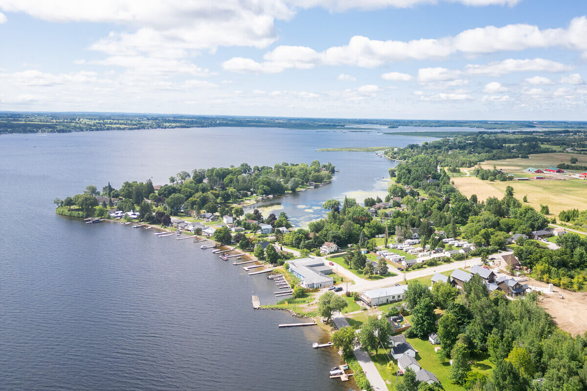 Large lake view with residential area and greenery, aerial real estate photography Canada