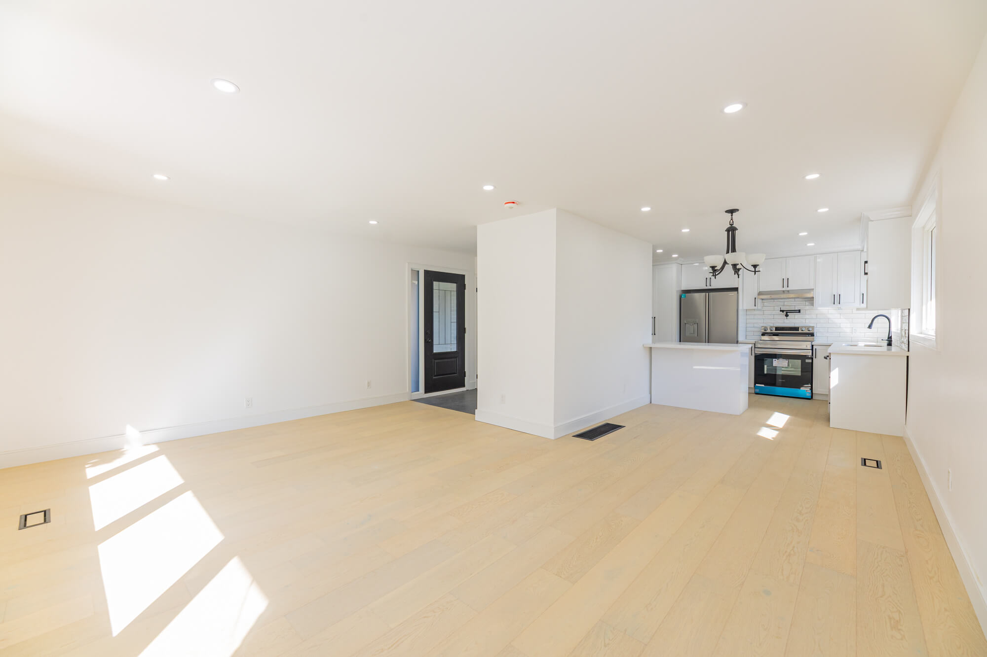 Empty basement living room before virtual staging in Scarborough home with fireplace and open layout